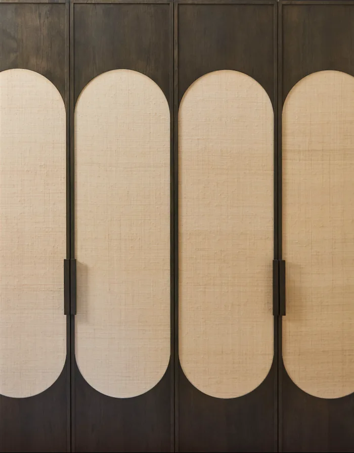 Curved cane panels framed by dark timber