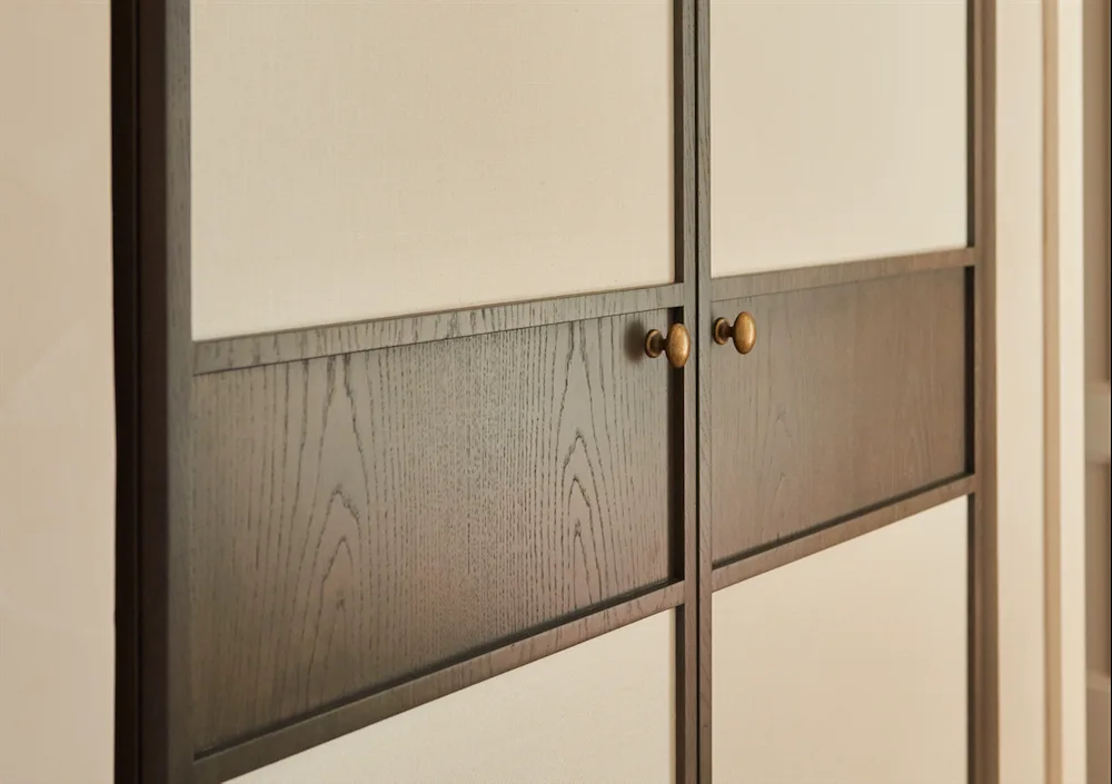 Dark timber cabinetry with brass handles